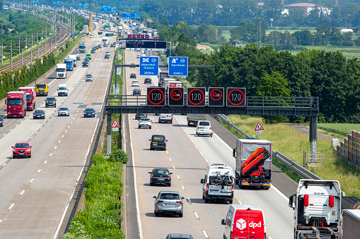 Weilbach, Germany - June 10, 2021: Large trucks and dense traffic on autobahn A3 near Wiesbadener Kreuz. The Bundesautobahn 3 (abbreviated as BAB 3 or A 3) is a highway in Germany that links the border to the Netherlands near Wesel in the northwest to the Austrian border near Passau in the southeast.