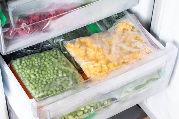istock Plastic bags with different frozen vegetables in refrigerator. 1337909152