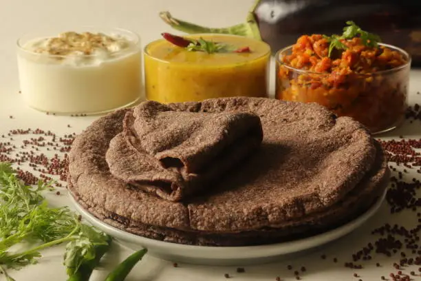 Indian flatbread made of finger millet flour. Served with a fire roasted brinjal dish, Lentil curry and spiced curd. commonly known in Indian as ragi roti, baingan bharta and dal curry.