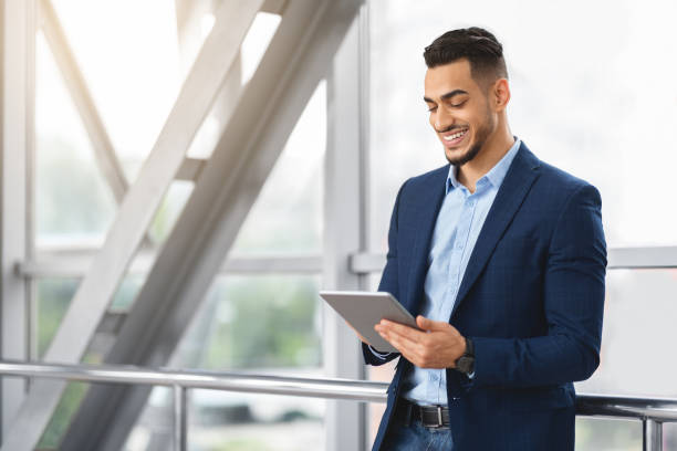 istock Handsome Young Arab Businessman Using Digital Tablet While Waiting At Airport Terminal 1337913218