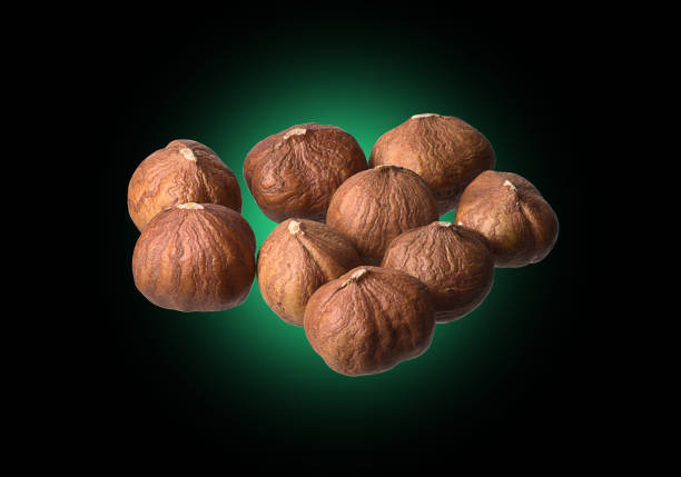 Handful of peeled hazelnuts on a black background.