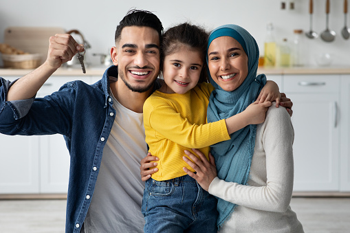 Moving Day. Happy Middle Eeastern Family With Little Daughter Holding Home Keys, Cheerful Islamic Man, Woman And Female Child Celebrating Buying New Property, Enjoying House Ownership, Closeup