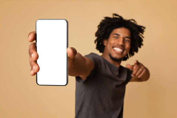 istock Joyful Black Guy Demonstrating Smartphone With Blank White Screen In His Hand 1337919499