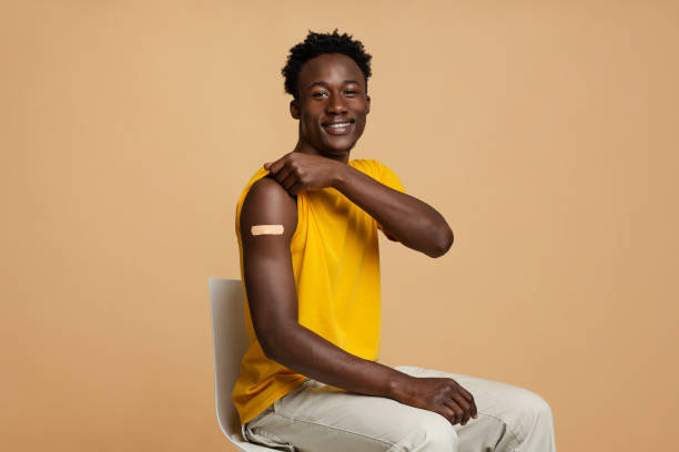 istock Im Vaccinated. Black Guy Showing Arm With Adhesive Bandage After Successful Vaccination 1337919780