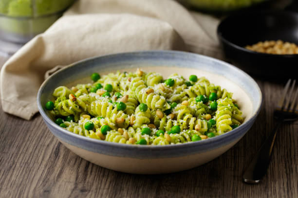 gesunde fusilli-pasta mit grünen erbsen und veganer brokkoli-pestosauce - pine nut fotos stock-fotos und bilder