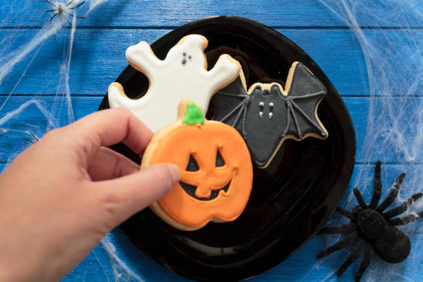 istock Top view of woman's hand holding halloween cookie 1337929046