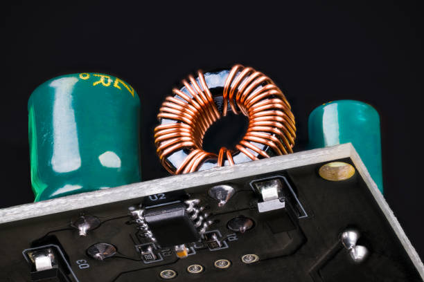 istock Printed circuit board with toroidal coil with ferrite core or green capacitors on a black background 1337929104