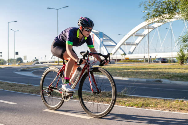 ciclista in sella a una bicicletta all'aperto. - cyclist cycling road women foto e immagini stock