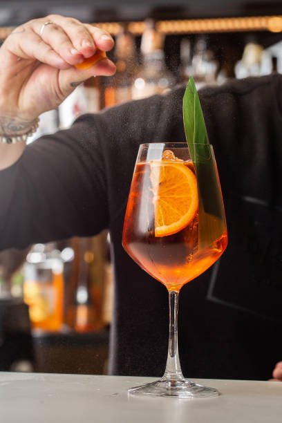 istock Bartender preparing on the counter Spritz, a classic refreshing Italian aperitif made mixing Aperol, Prosecco and sparkling soda 1337935564
