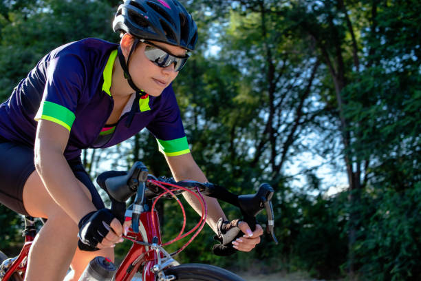 ciclista in sella a una bicicletta all'aperto. - cyclist cycling road women foto e immagini stock