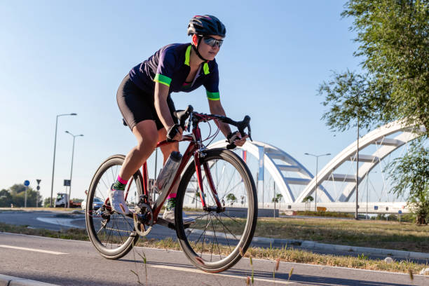 ciclista in sella a una bicicletta all'aperto. - cyclist cycling road women foto e immagini stock