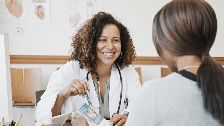 Female doctor discusses healthcare brochure with patient