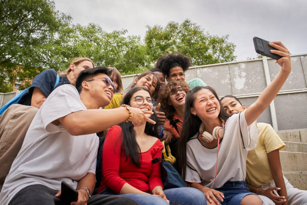 istock Group of multi-ethnic students taking selfies with mobile phone. Teenagers using a smart phone and having fun together. 1337938202