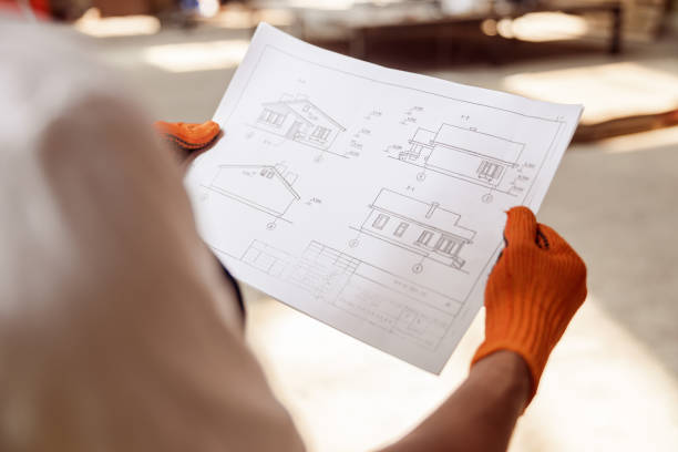 istock Male builder hands in gloves holding architectural plan 1337943547