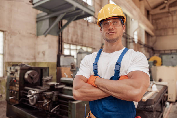 istock Athletic male builder in construction helmet standing in workshop 1337943726