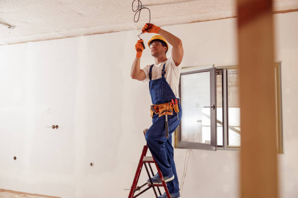 istock Smiling electrician fixing electric cable on ceiling 1337944325