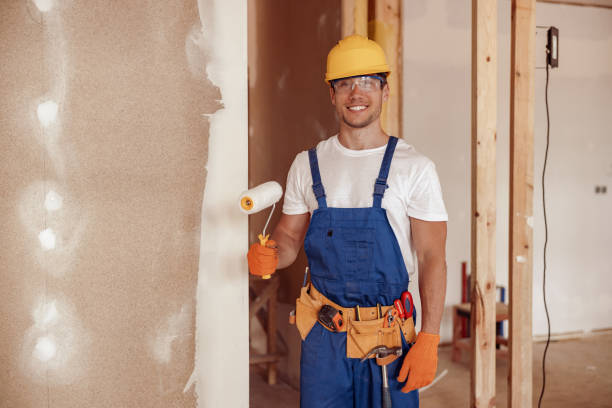 istock Joyful male builder painting wall in house under construction 1337944340
