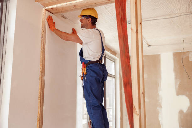 istock Male worker hanging wallpaper on the wall 1337944348