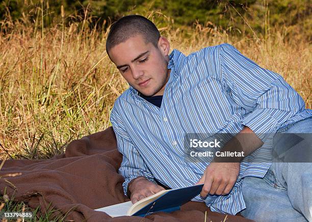 Photo libre de droit de Mentir Jeune Garçon Lisant Un Livre À Lextérieur banque d'images et plus d'images libres de droit de Hommes - Hommes, Jeans baggy, Adolescent