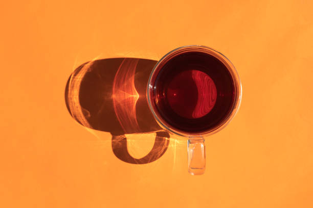 istock a mug of tea with a hard shadow on an orange background 1337954808