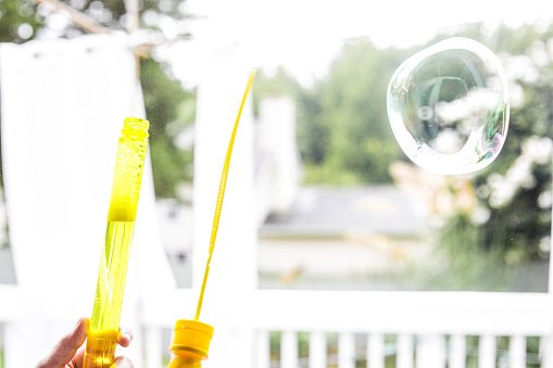 Yellow bubble wand in the back yard