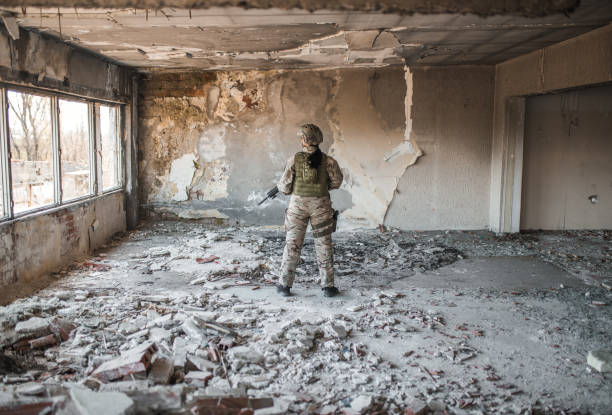 istock Female soldier in uniform in war zone in abandoned warehouse 1337978191