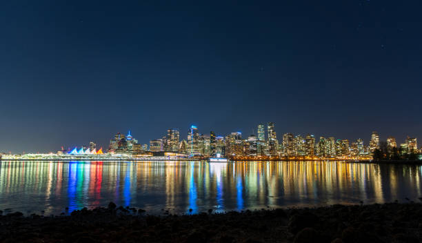 Vancouver downtown skyline night panorama. British Columbia, Canada. Vancouver downtown skyline night panorama. Colorful buildings lights reflections on waterfront harbor water surface. British Columbia, Canada. vancouver at night stock pictures, royalty-free photos & images