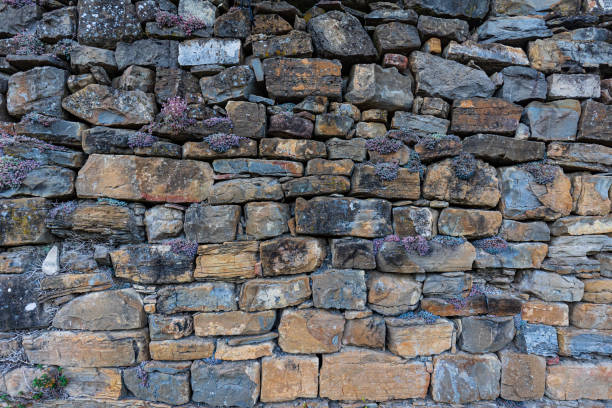 muro de piedra real para fondo, construcción típica del mundo rural y de las zonas de montaña. - retro revival pattern masonry old fotografías e imágenes de stock