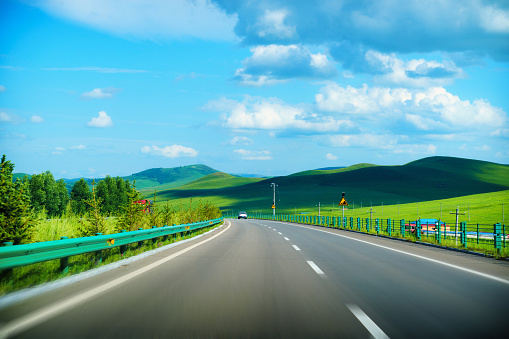 The Italian highway crosses the Po Valley countryside near Turin with a view of the snow-capped Cozie Alps in the background