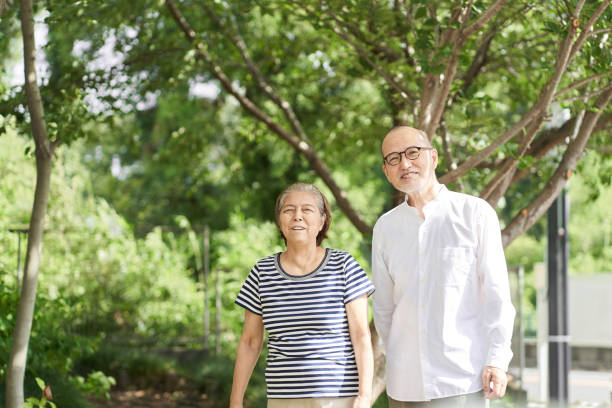 istock Elderly couple taking a walk in the park with a smile 1337997524