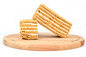 Two pieces of honey cake on a wooden cutting board isolated on a white background.