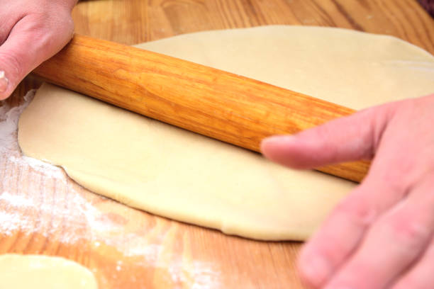 istock Female hands rolling the dough into a thin pancake with a rolling pin 1337999112