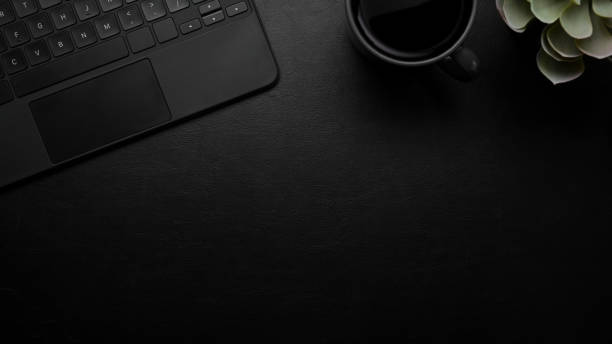 istock Modern dark leather desk with mockup place, keyboard, black background 1338003170