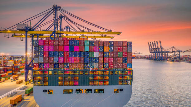 container ship working at night, business import export logistic and transportation of international by container ship in the open sea, aerial view industrial crane loading cargo freight seaport. - navio cargueiro imagens e fotografias de stock