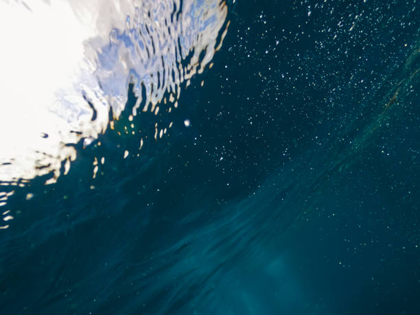istock Sun light beams shining from above coming through the deep blue water causing a reflections curtain. 1338004430
