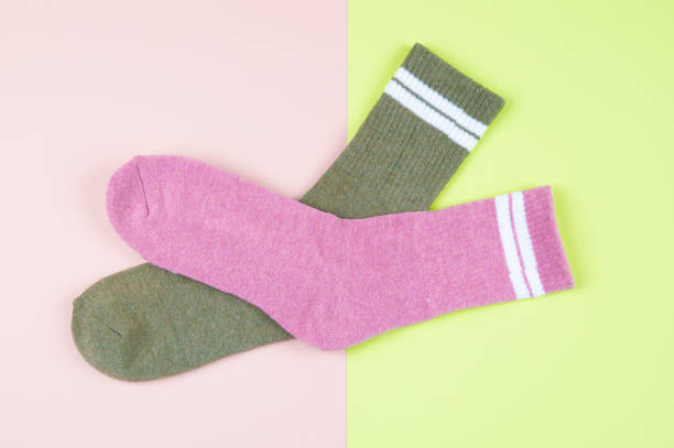 istock Two socks green and pink on a pastel multi-colored pink and green background with copy space, top view 1338005424