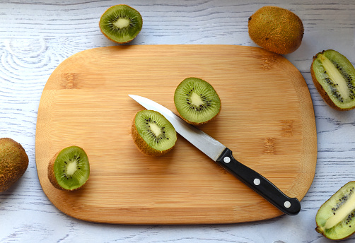 Sliced kiwi on cutting board with knife