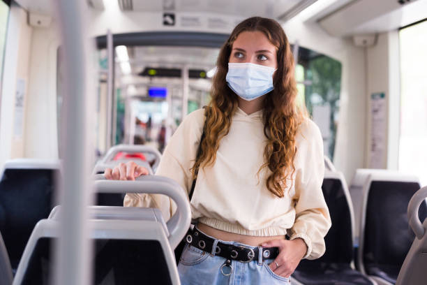 istock Young lady in face mask riding on tram to her work 1338007557
