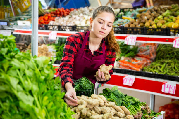 istock Smiling female seller lay out ginger on the counter 1338007765