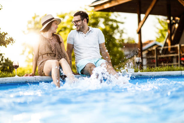 istock Happy couple having fun while splashing water in the pool. 1338009912