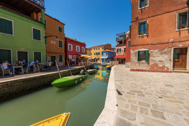 outdoors restaurants and canal with moored boats in burano island - venice italy - travel outdoors tourist venice italy imagens e fotografias de stock