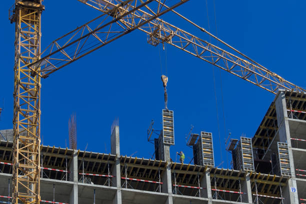 istock Professional high-rise installers work on the top floor of a new building under construction. 1338012012