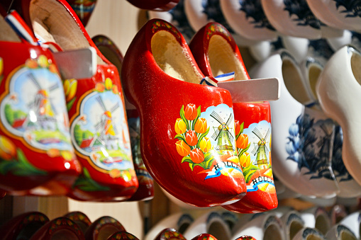 Rack with rows traditional dutch red wooden klompen or clogs shoes, Netherlands