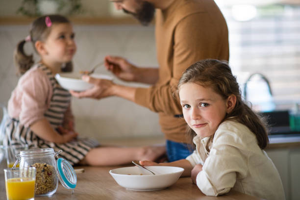 istock Father with daughters indoors at home, eating breakfast in kitchen. 1338013045