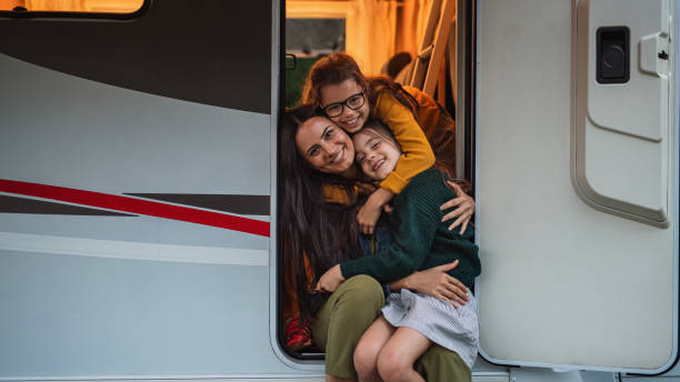 madre con hijas en coche al aire libre en camping al atardecer, caravana viaje de vacaciones familiares. - caravana tráiler de vehículos fotografías e imágenes de stock