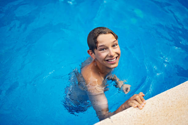 little boy enjoying swimming in swimming pool - swimming child swimwear little boys imagens e fotografias de stock