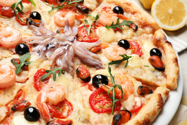 istock Tasty fresh pizza with seafood on table, closeup 1338017883