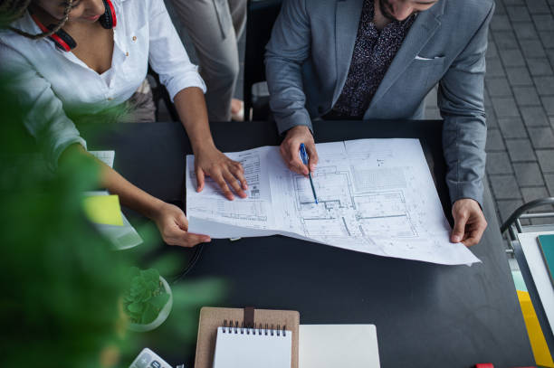 istock Top view of unrecognizable architects sitting and working at desk in office, cooperation concept. 1338019590