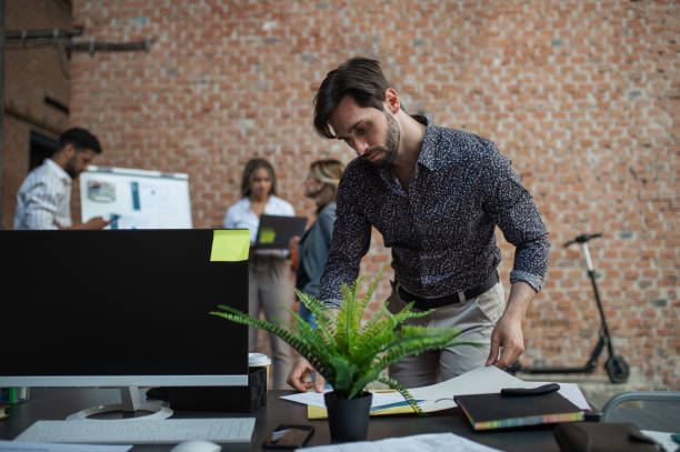 istock Young businessman standing and working in office, cooperation, presentation and brainstorming concept. 1338019800