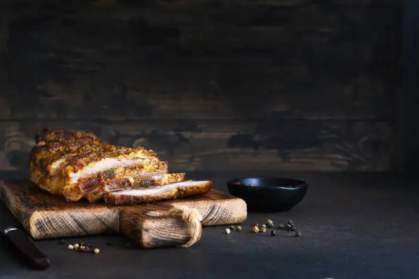 Baked boiled pork.Baked meat slice with garlic and spices on a wooden board.